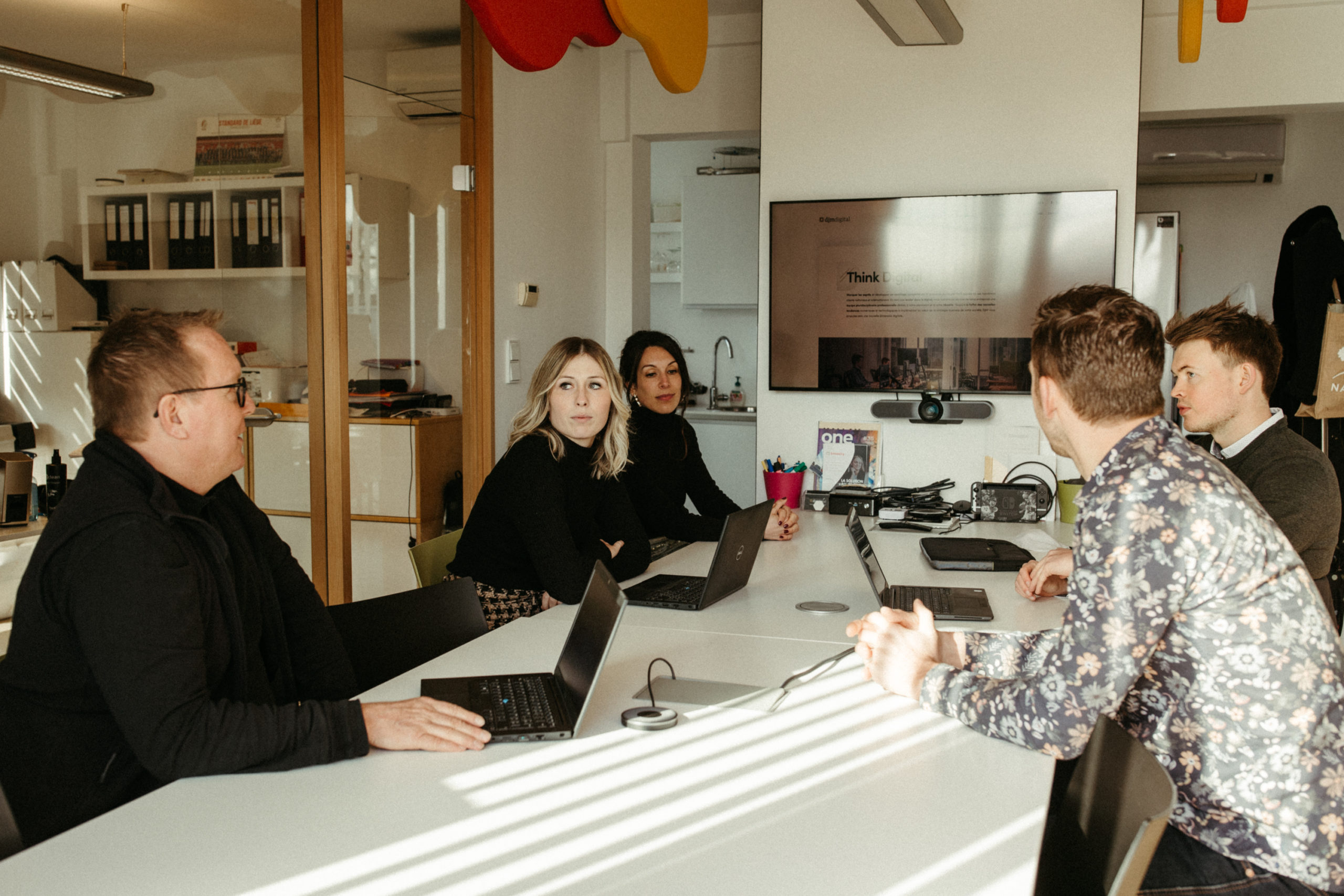 Réunion d'équipe chez DJM digital : collaborateurs concentrés autour d'une table, échangeant des idées et travaillant sur des stratégies innovantes pour accompagner les TPE et PME dans leur transformation digitale.